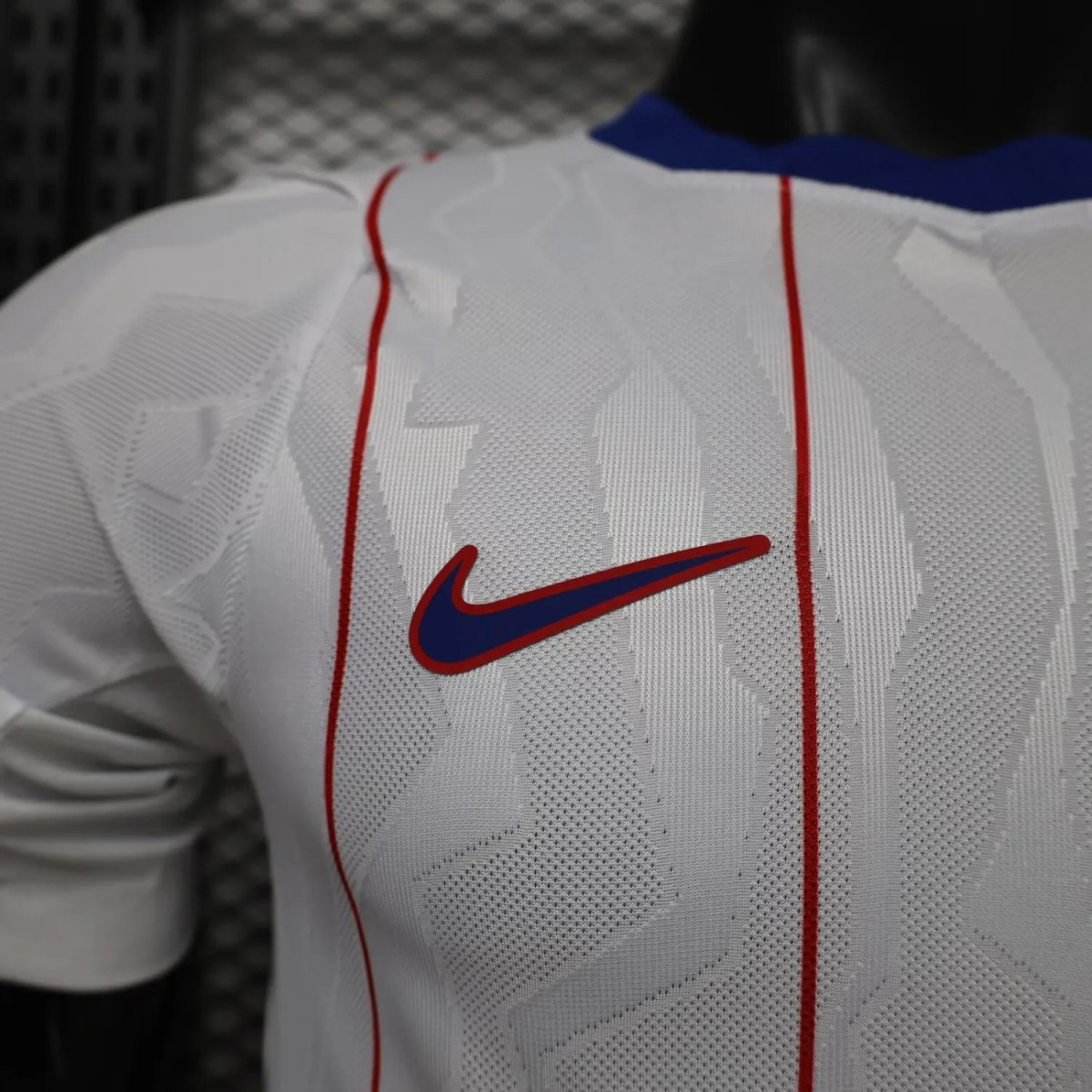 Détail du swoosh Nike bleu et rouge et du jacquard blanc sur blanc